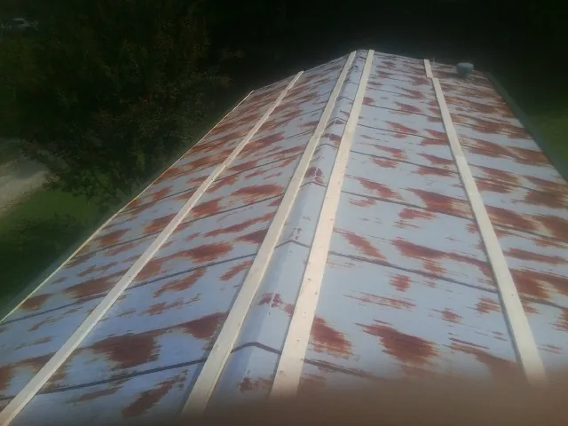 Rusted metal roof panels with new wood purlins before replacement — Storm Damage Roof Repair in Claryville by Roofing Brothers