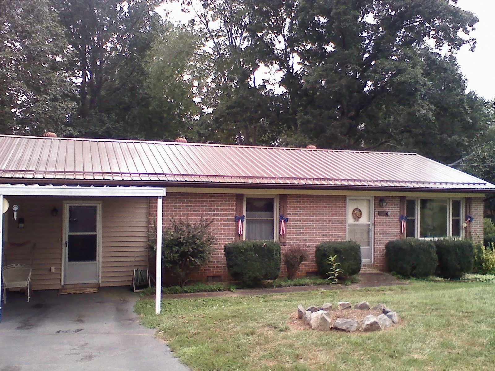 Bronze metal roof and carport on a brick ranch home — Roof Repair work by our crew in Claryville