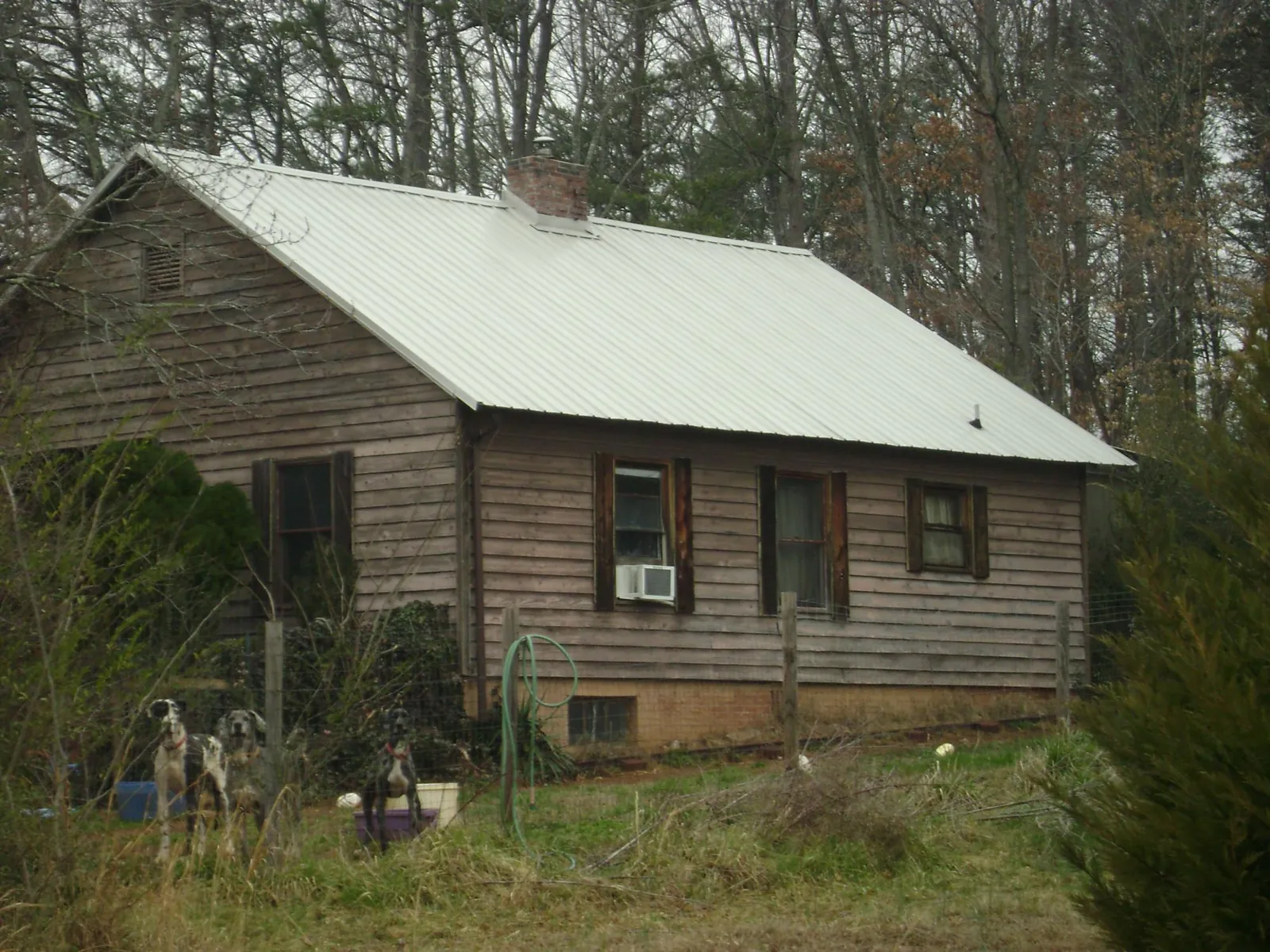 White metal roof on an old wood sided farmhouse, from a Metal Roof Installation job in Claryville